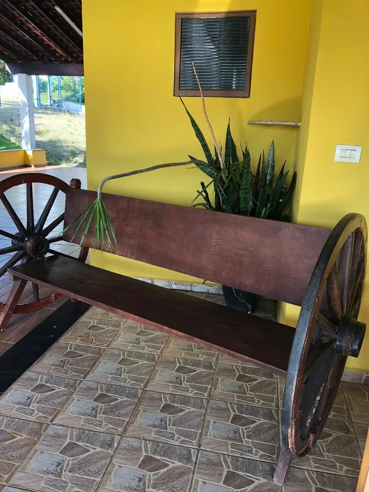Banco decorativo em área coberta, com plantas e vista para o jardim